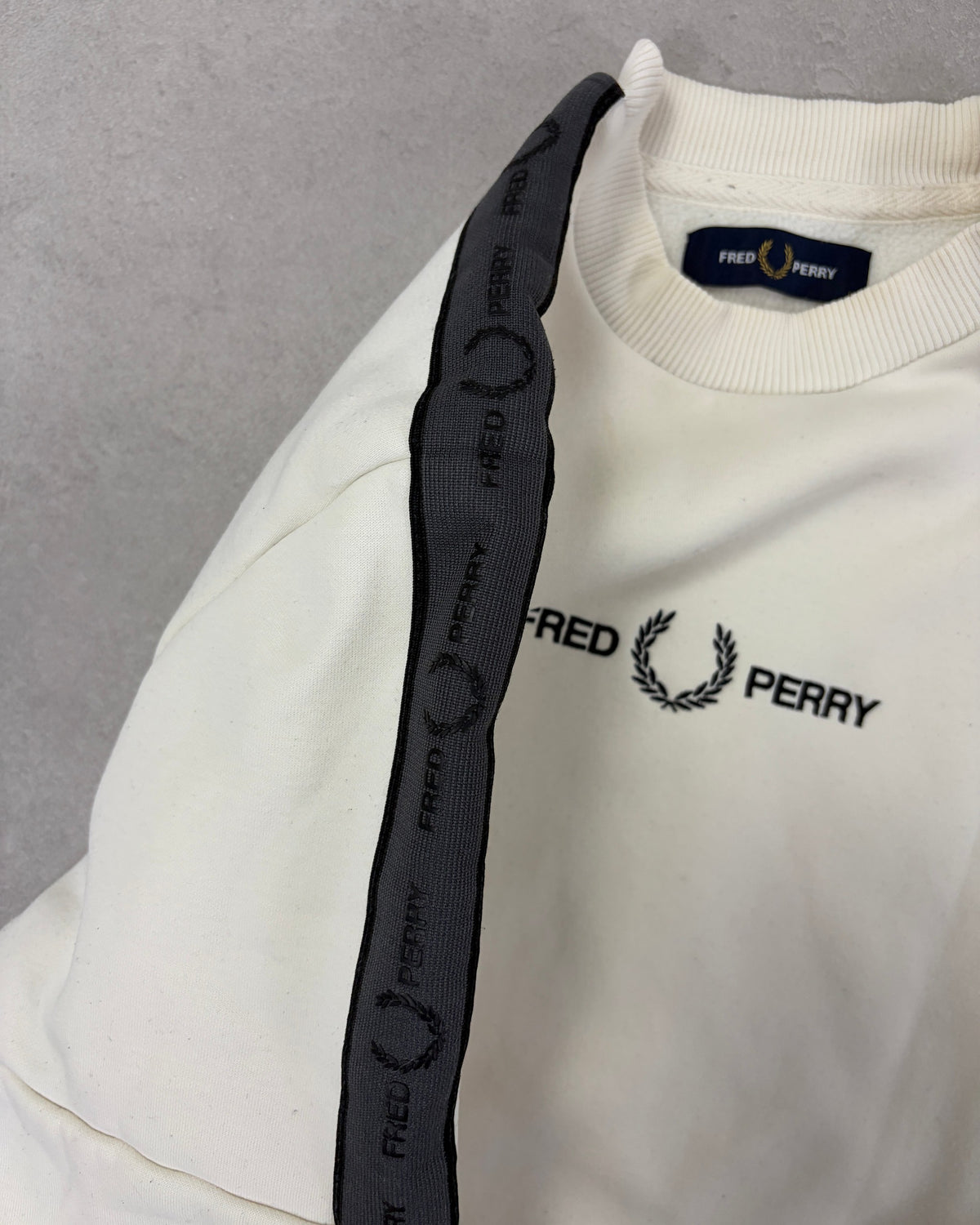 Fred Perry Pullover Creme mit schwarzem Ärmel-Tape – Detail