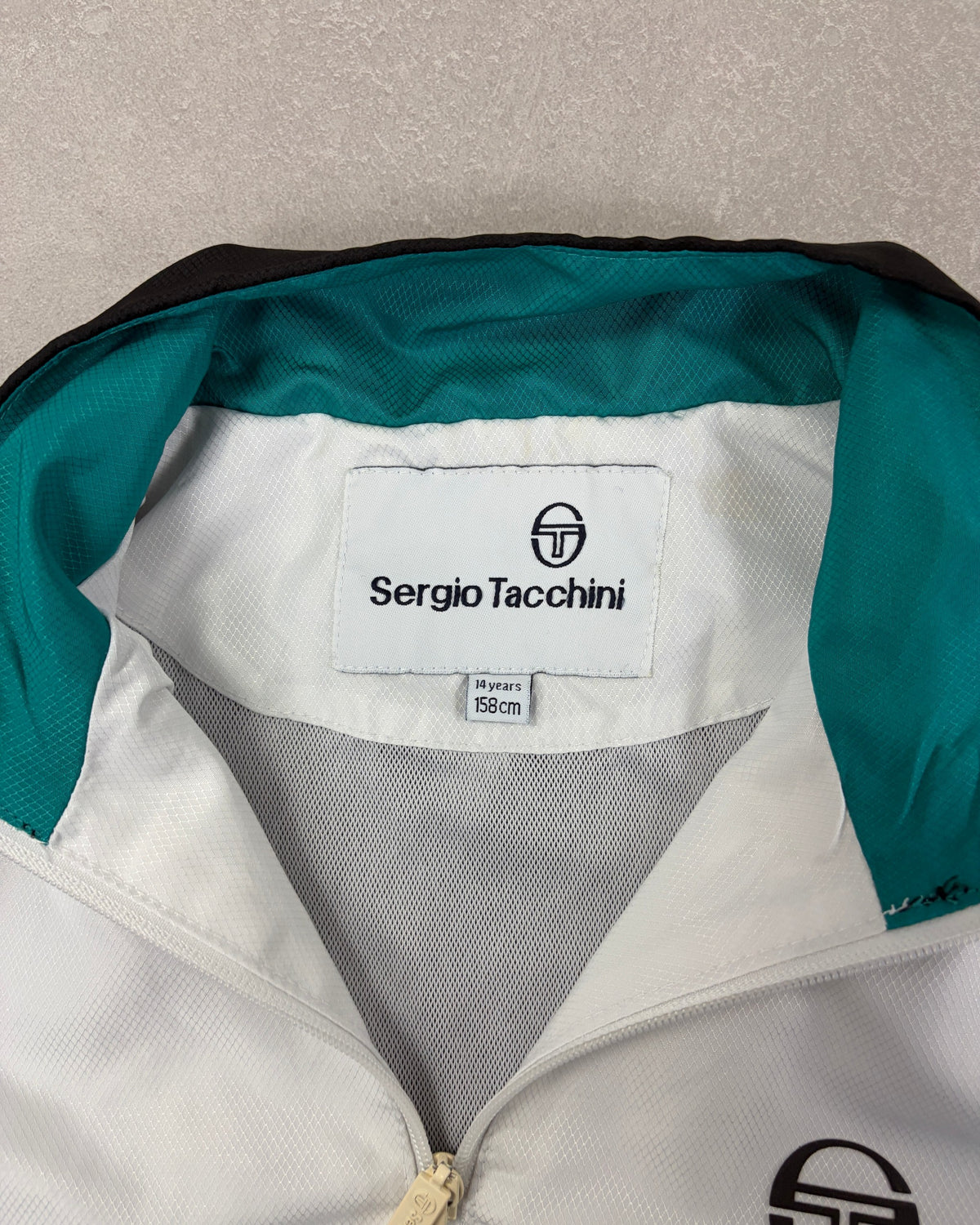 Sergio Tacchini Kinder-Trainingsjacke Schwarz-Weiß-Türkis – Etikett
