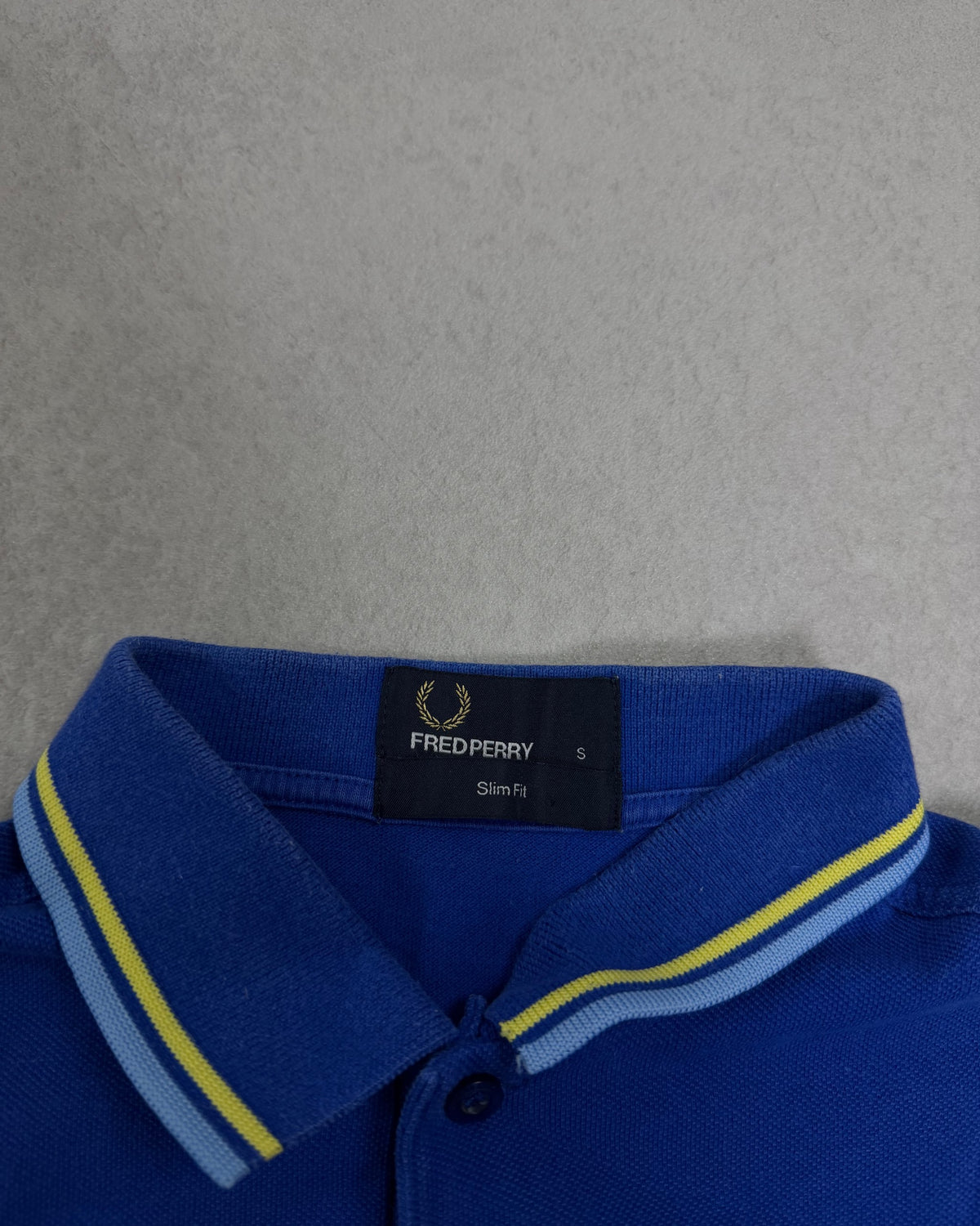 Fred Perry Poloshirt Royalblau mit gelbem Tipping – Etikett