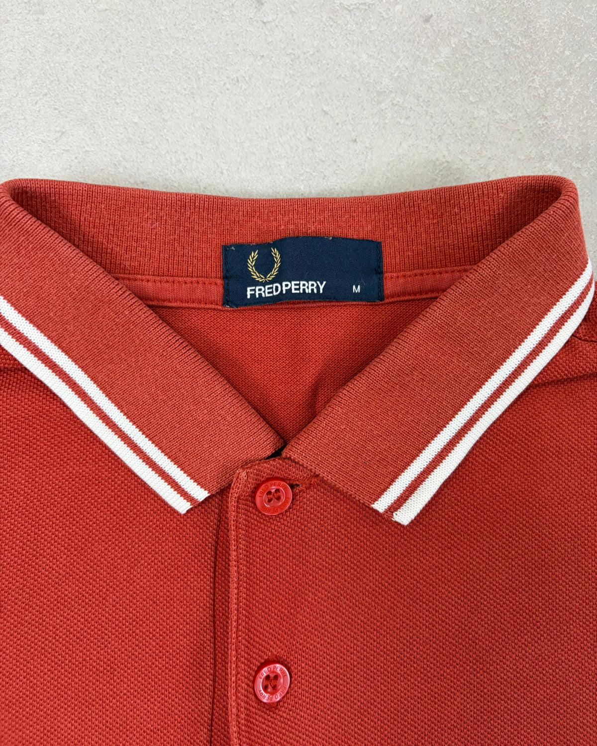 Fred Perry Poloshirt Rostrot mit weißen Streifen – Etikett