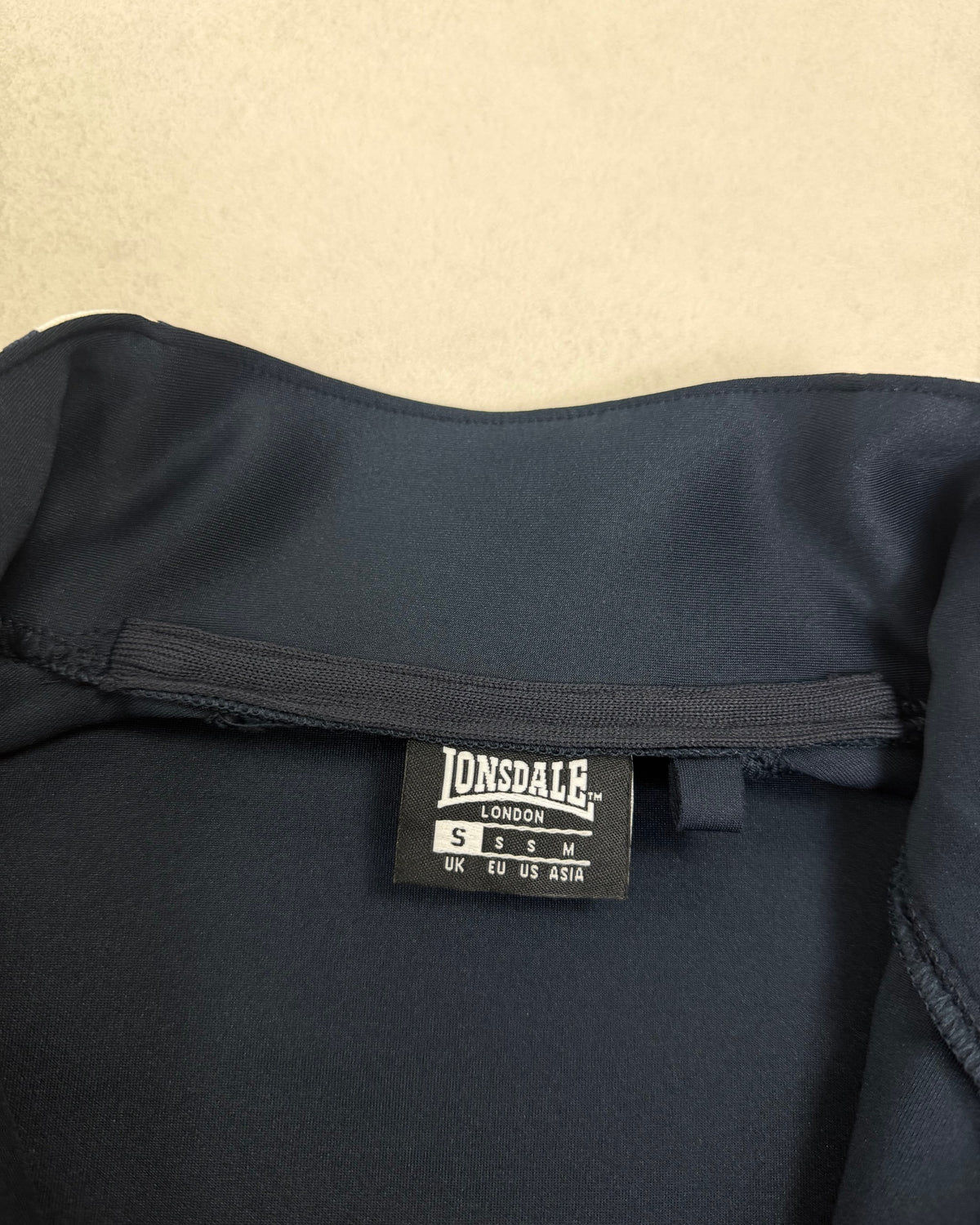 Lonsdale Trainingsjacke Navy mit weißen Schulterstreifen Größe S – Etikett