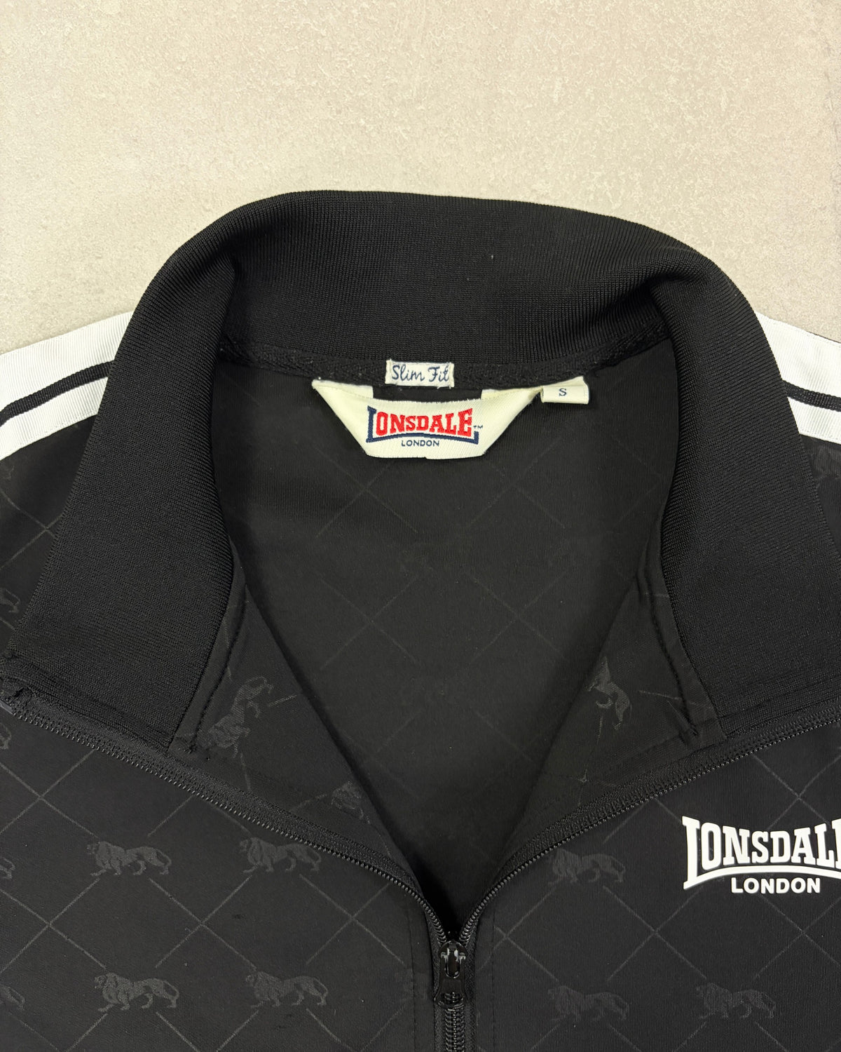 Lonsdale Trainingsjacke Schwarz mit Allover-Löwen Slim Fit Größe S – Etikett
